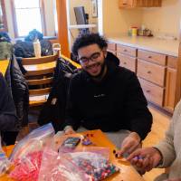 three students at table bagging food